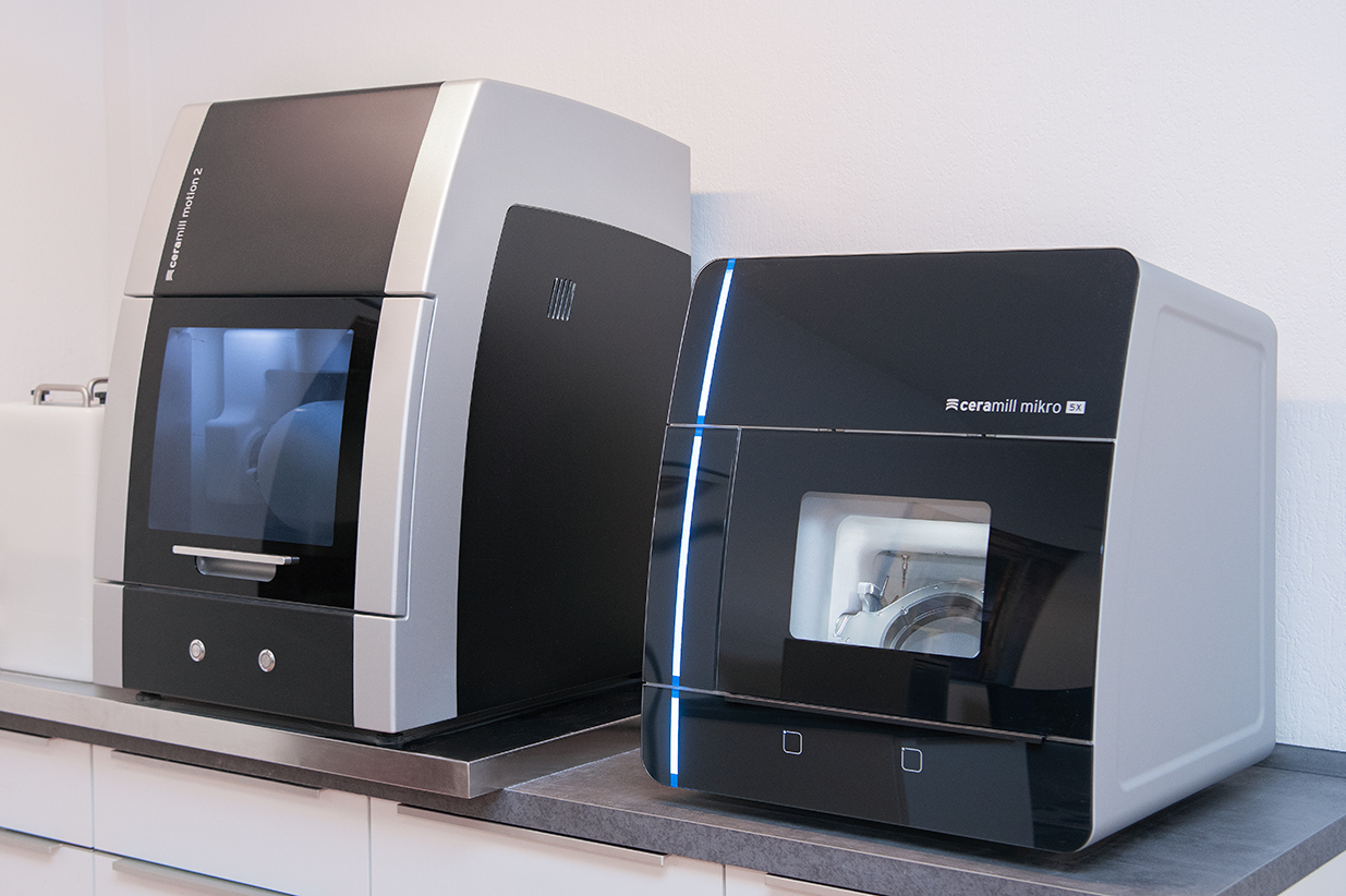 Zwei moderne Fräsmaschinen zur Herstellung von Zahnersatz in einem Labor.